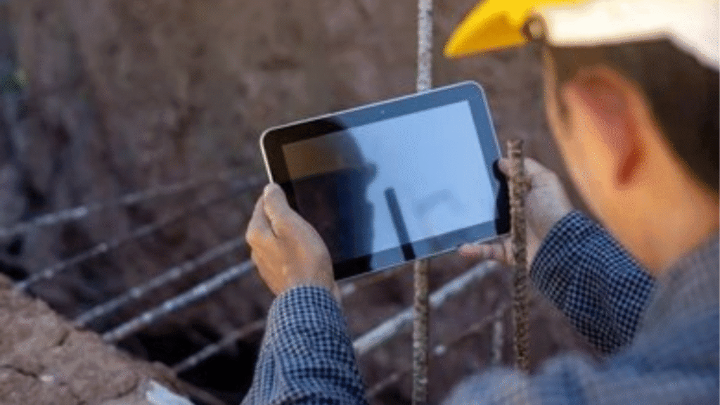 Image of a construction site manager using a tablet to show a client the digital project timeline and invoice tracking.