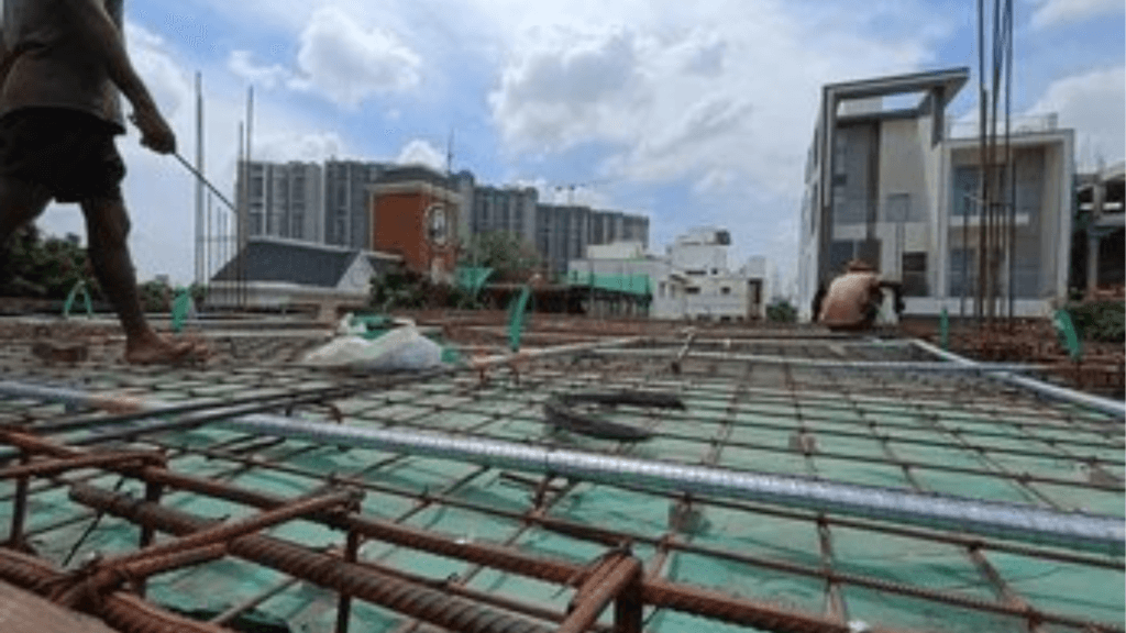 Workers pouring concrete on a residential construction site in Bangalore