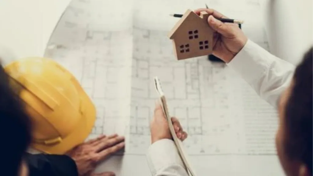 architect and client discussing a house floor plan on a construction site in bangalore
